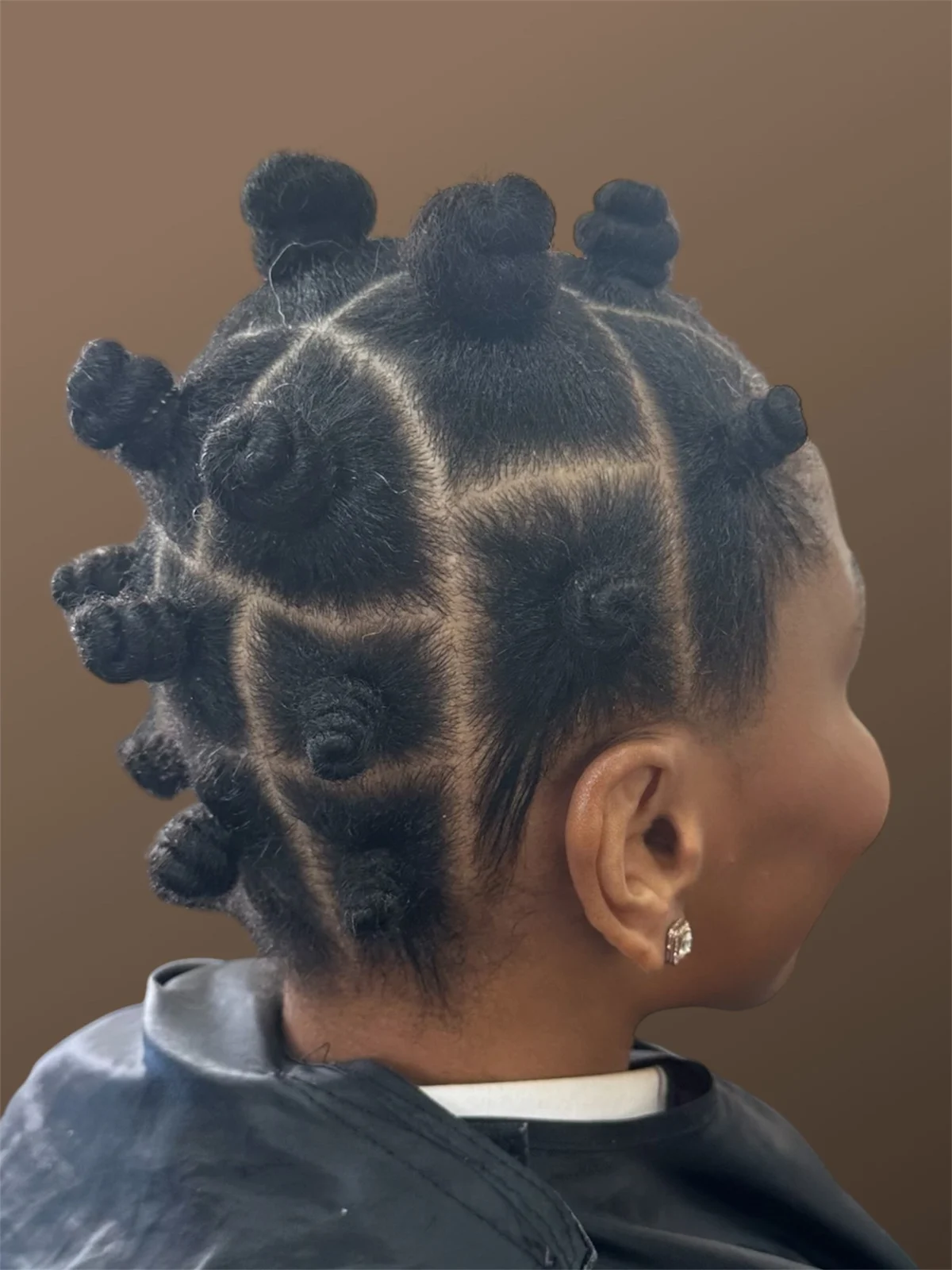 Bantu knots with precise geometric sectioning, seen from the side.